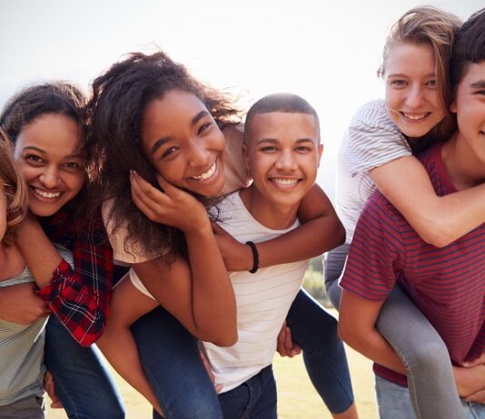 Konfirmation, Kommunion und Co. Glückliche Jugendliche umarmen sich