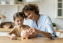 Weltspartag: Die Ergebnisse des Vermögensbarometers Weltspartag: Eine Mutter und ihre Tochter stecken Geld in ein Sparschwein.