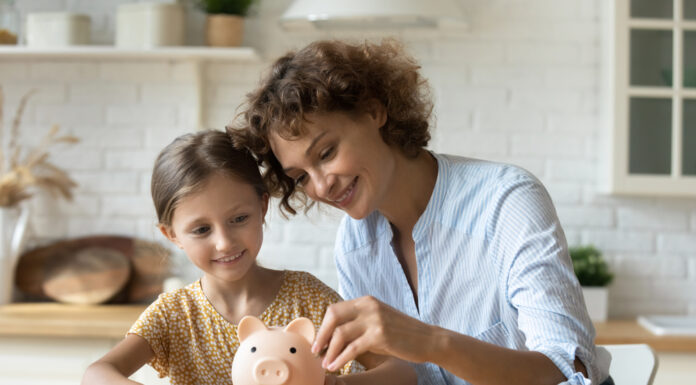 Weltspartag: Die Ergebnisse des Vermögensbarometers Weltspartag: Eine Mutter und ihre Tochter stecken Geld in ein Sparschwein.