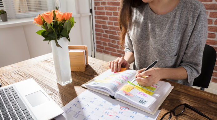 10 Fragen rund um Ihren Urlaub Frau sitzt am Schreibtisch vor einem Terminplaner