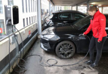 Echt nachhaltig: Förde Sparkasse unterstützt Verkehrswende Eine Mitarbeiterin der Förde Sparkasse lädt ihr E-Auto an einer Ladesäule auf.