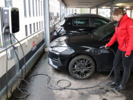 Echt nachhaltig: Förde Sparkasse unterstützt Verkehrswende Eine Mitarbeiterin der Förde Sparkasse lädt ihr E-Auto an einer Ladesäule auf.