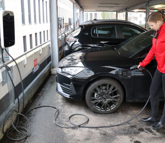 Echt nachhaltig: Förde Sparkasse unterstützt Verkehrswende Eine Mitarbeiterin der Förde Sparkasse lädt ihr E-Auto an einer Ladesäule auf.