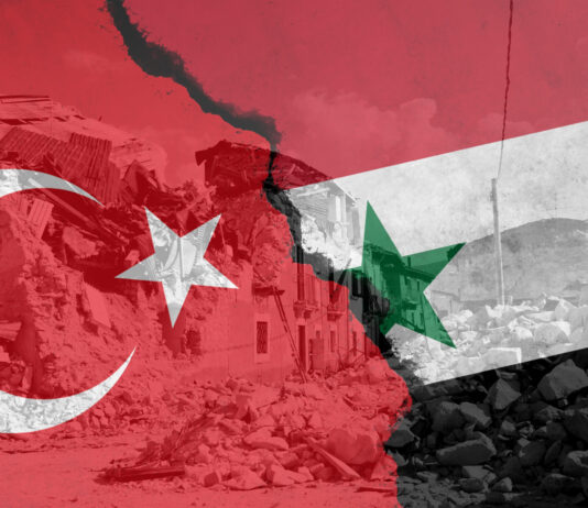 Erdbeben in Türkei und Syrien: So können Sie helfen Zerstörte Gebäude nach einem Erdbeben, darüber liegen die Fahnen der Türkei und Syrien.