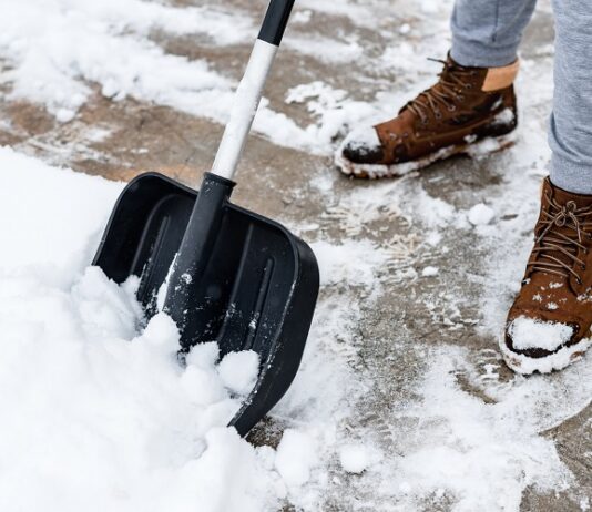 Kennen Sie Ihre Winterdienstpflicht? Winterdienstpflicht: Person schippt Schnee vom Gehweg