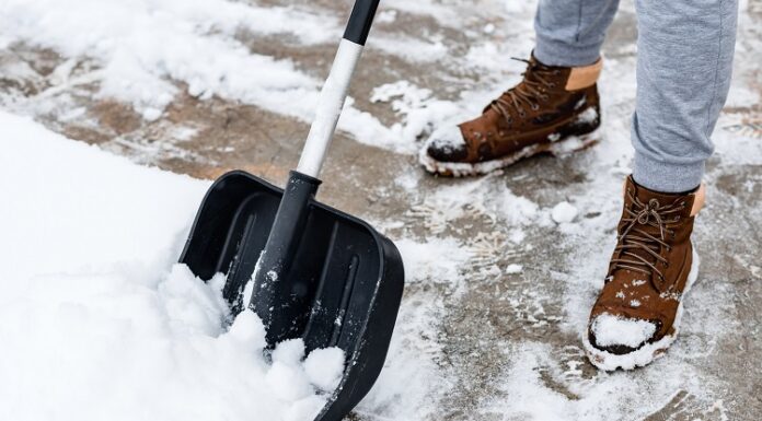 Kennen Sie Ihre Winterdienstpflicht? Winterdienstpflicht: Person schippt Schnee vom Gehweg