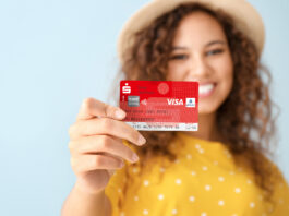 Neue Sparkassen-Card erhält ein anderes Gesicht: Aus „Maestro“ wird bei uns „Visa Debit“ Eine junge Frau hält eine Sparkassen-Card in der Hand.