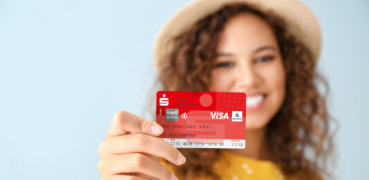 Neue Sparkassen-Card erhält ein anderes Gesicht: Aus „Maestro“ wird bei uns „Visa Debit“ Eine junge Frau hält eine Sparkassen-Card in der Hand.