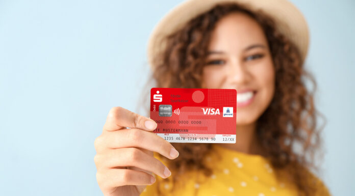 Neue Sparkassen-Card erhält ein anderes Gesicht: Aus „Maestro“ wird bei uns „Visa Debit“ Eine junge Frau hält eine Sparkassen-Card in der Hand.