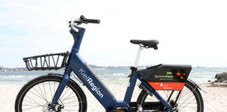 SprottenFlotte: Wir schenken Ihnen Freiminuten Neues blaues E-Bike der SprotteFlotte am Strand von Eckernförde.