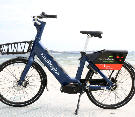 Anbieterwechsel bei der SprottenFlotte: Die neuen E-Bikes sind da Neues blaues E-Bike der SprotteFlotte am Strand von Eckernförde.