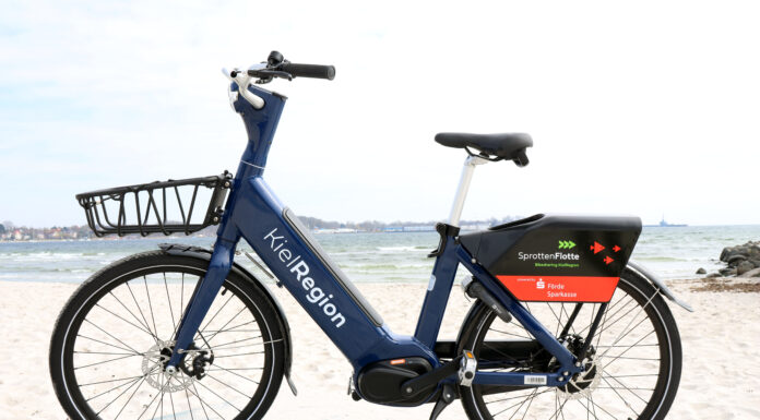 Anbieterwechsel bei der SprottenFlotte: Die neuen E-Bikes sind da Neues blaues E-Bike der SprotteFlotte am Strand von Eckernförde.