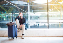 Flug verspätet oder gestrichen? Diese Rechte haben Sie jetzt Mann sitzt verärgert am Flughafen, weil sein Flug verspätet ist