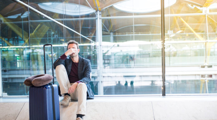 Fluggastrechte: Diese Entschädigungen bekommen Sie Mann sitzt verärgert am Flughafen, weil sein Flug verspätet ist