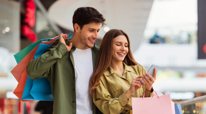 Bonusprogramme in Zeiten von Inflation: Das Instrument zur Kundenbindung und Neukundengewinnung im Einzelhandel  Paar beim Shoppen mit Smartphone in der Hand. Bonusprogramm zur Kundenbindung.