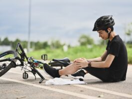 Private Unfallversicherung: Richtig abgesichert bei Freizeitunfällen Junger Radfahrer, der einen Unfall hatte, vom Fahrrad herunterfiel und sein Knie verletzte