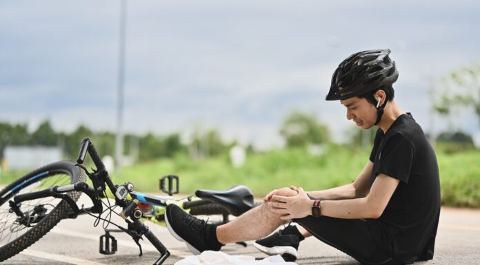 Private Unfallversicherung: Richtig abgesichert bei Freizeitunfällen Junger Radfahrer, der einen Unfall hatte, vom Fahrrad herunterfiel und sein Knie verletzte