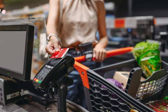 Frau bezahlt mit Sparkassenkarte an der Supermarktkasse