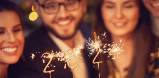 Neues Jahr, neue Regelungen: Das bringt uns 2024 Zwei schöne junge Paare, die sich auf der Neujahrsfeier amüsieren