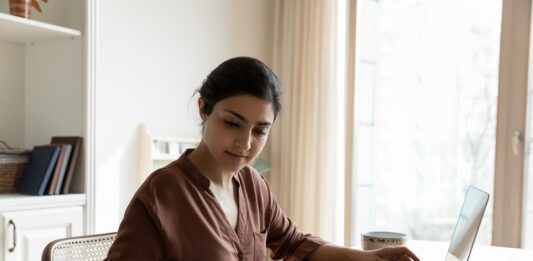 Zinswende und ihre Folgen: Die Rückkehr der Vorabpauschale für Fondsanleger Frau mit Taschenrechner im privaten Büro