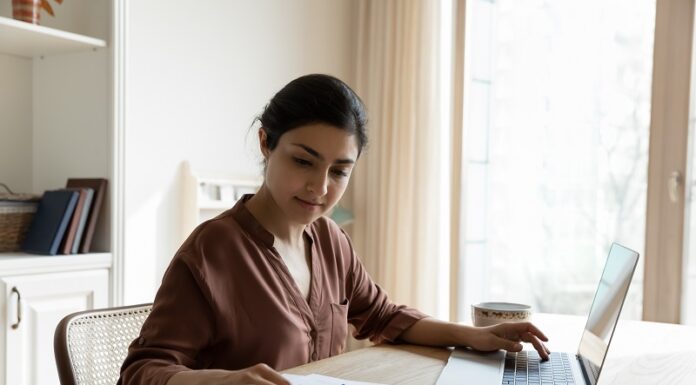 Zinswende und ihre Folgen: Die Rückkehr der Vorabpauschale für Fondsanleger Frau mit Taschenrechner im privaten Büro