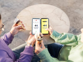 Europas neuer Stern am Zahlungshimmel: wero Zwei Menschen sitzen nebeneinander und haben Eistüten in der Hand, sie halten ihre Smartphones nebeneinander und bezahlen mit dem neuen Bezahlsystem wero