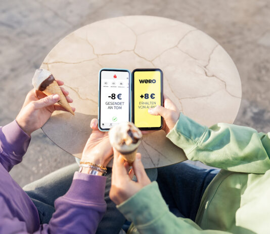Europas neuer Stern am Zahlungshimmel: wero Zwei Menschen sitzen nebeneinander und haben Eistüten in der Hand, sie halten ihre Smartphones nebeneinander und bezahlen mit dem neuen Bezahlsystem wero