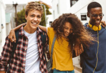 Förde Sparkasse unterstützt den Deutschen Gründerpreis für Schüler:innen (DGPS) 2026 Drie Teenager laufen Arm und Arm und lachen