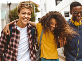 Förde Sparkasse unterstützt den Deutschen Gründerpreis für Schüler:innen (DGPS) 2026 Drie Teenager laufen Arm und Arm und lachen