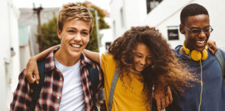 Förde Sparkasse unterstützt den Deutschen Gründerpreis für Schüler:innen (DGPS) 2026 Drie Teenager laufen Arm und Arm und lachen