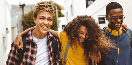 Förde Sparkasse unterstützt den Deutschen Gründerpreis für Schüler:innen (DGPS) 2026 Drie Teenager laufen Arm und Arm und lachen