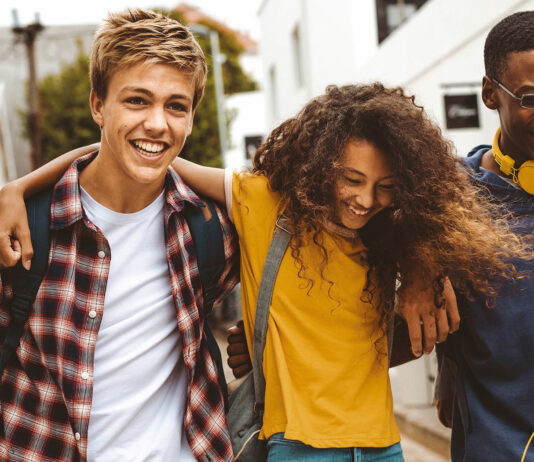 Förde Sparkasse unterstützt den Deutschen Gründerpreis für Schüler:innen (DGPS) 2026 Drie Teenager laufen Arm und Arm und lachen