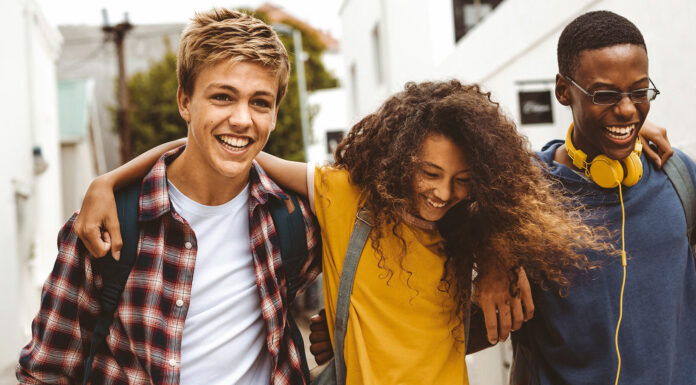 Förde Sparkasse unterstützt den Deutschen Gründerpreis für Schüler:innen (DGPS) 2026 Drie Teenager laufen Arm und Arm und lachen