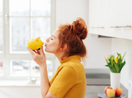 Die 5 besten Spar-Challenges – Kreative Spartipps Rothaarige Frau küsst ein gelbes Sparschwein