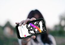 NEU: Förde Sparkasse bei Threads Frau hält Smartphone vor ihr Gesicht, darauf ist die Threads App zu sehen