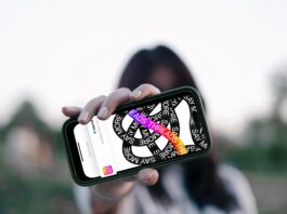 NEU: Förde Sparkasse bei Threads Frau hält Smartphone vor ihr Gesicht, darauf ist die Threads App zu sehen