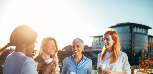 Gleiche Chancen, gleiche Rechte? So steht es um die Frauen tatsächlich Vier Business Frauen stehen nebeneinander und haben einen Coffee to go in den Händen