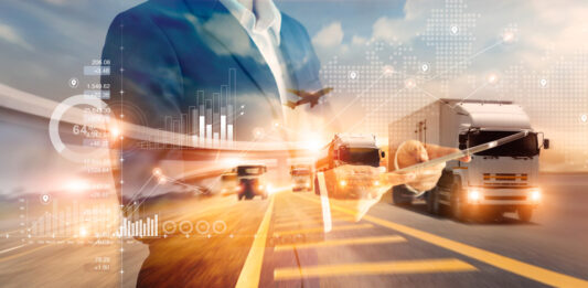 Deutschland brummt leiser – vorerst Mann im Anzug, im Hintergrund eine Autobahn mit LKW, ein Flugzeug am Himmel.