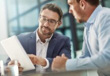 Noch mehr Nähe, noch kürzere Wege Tablet, Treffen von zwei Geschäftsleuten in der Bürodiskussion