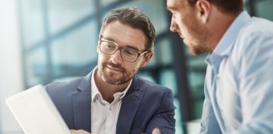 Noch mehr Nähe, noch kürzere Wege Tablet, Treffen von zwei Geschäftsleuten in der Bürodiskussion