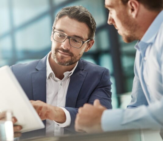 Noch mehr Nähe, noch kürzere Wege Tablet, Treffen von zwei Geschäftsleuten in der Bürodiskussion