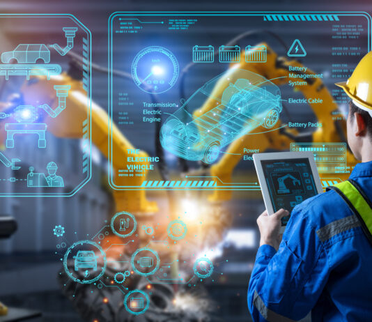 Arbeitsabläufe modern gestalten durch Prozessdigitalisierung Ein Mann steht vor einer Glaswand in der Produktion.