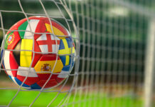 Fußball EM 2024: Mitfiebern und gewinnen Fußball mit Flaggen von europäischen Ländern im Netz der Tore des Fußballstadions.