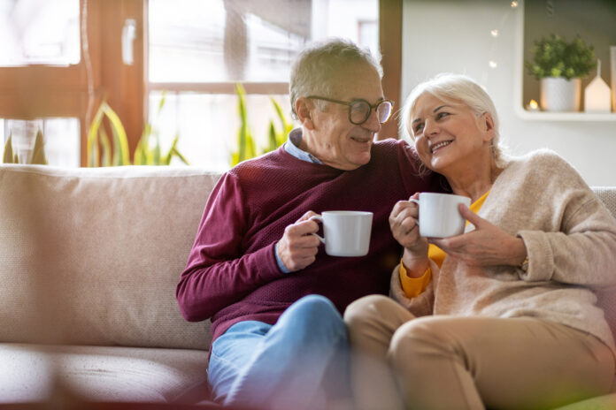 Porträt eines glücklichen älteren Ehepaares, das sich zu Hause auf dem Sofa entspannt