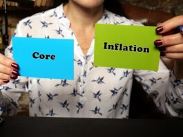 Kerninflation und Inflation – warum dieser Unterschied? Frau hält zwei Schilder mit Core und Inflation hoch