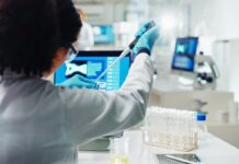 Gesundmacher fürs Wertpapier-Portfolio Labor Mitarbeiterin nimmt mit Pipette eine Probe aus einem Reagenzglas