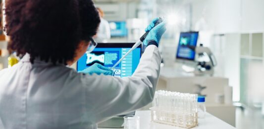 Gesundmacher fürs Wertpapier-Portfolio Labor Mitarbeiterin nimmt mit Pipette eine Probe aus einem Reagenzglas