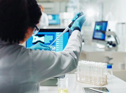 Gesundmacher fürs Wertpapier-Portfolio Labor Mitarbeiterin nimmt mit Pipette eine Probe aus einem Reagenzglas