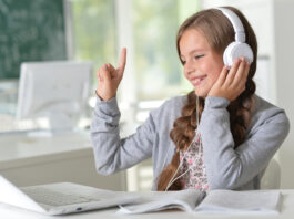 ubiMaster: Lernen leicht gemacht – Kostenlos mit MEINKonto SMART! Ein Mädchen mit Kopfhörern sitzt vor einem Laptop.