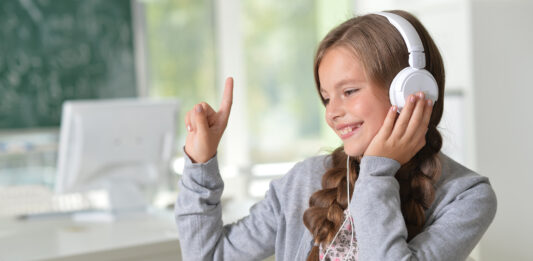 ubiMaster: Lernen leicht gemacht – Kostenlos mit MEINKonto SMART! Ein Mädchen mit Kopfhörern sitzt vor einem Laptop.